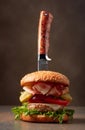 Fresh burger with knife on a brown background