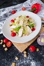 Fresh caesar salad with chicken on a white plate on dark stone background. Flat lay with ingridients for cook. Royalty Free Stock Photo