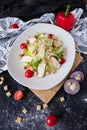 Fresh caesar salad with chicken on a white plate on dark stone background. Flat lay with ingridients for cook. Royalty Free Stock Photo