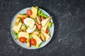 Fresh caesar salad in plate on black stone table. Top