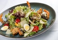 Fresh caesar salad on white bowl with parmesan cheese and shrimps. In a decorative plate Royalty Free Stock Photo