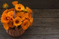 Fresh calendula flowers in a wicker basket on on wooden a table Royalty Free Stock Photo