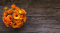 Fresh calendula flowers in a wicker basket on on wooden a table top view Royalty Free Stock Photo