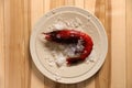 Fresh carabinero shrimp with ice on wooden table