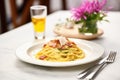 fresh carbonara served on a table with a fork and spoon crosswise Royalty Free Stock Photo
