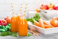 Fresh carrot and apple juice on white background. Carrot and apple juice in glass bottles on white table. Apple and carrot juice Royalty Free Stock Photo
