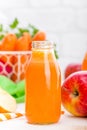 Fresh carrot and apple juice on white background. Carrot and apple juice in glass bottles on white table, closeup Royalty Free Stock Photo