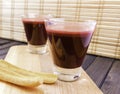 Fresh carrot and beetroot juice in glass decorated with carrot slices on wooden tray and bamboo background selective focus toned Royalty Free Stock Photo