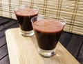 Fresh carrot and beetroot juice in glass on wooden tray and bamboo background selective focus toned Royalty Free Stock Photo