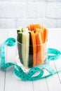 Fresh carrot and cucumber sticks in a glass. Centimeter measurement of volume. Concept of dietary nutrition. Copy space