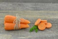 Fresh carrot and cuts slices of carrot on wooden table