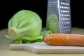 Fresh carrot grated on a metal kitchen grate. Vegetables prepared for salad with a meal on the kitchen table