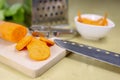 Fresh carrot grated on a metal kitchen grate. Vegetables prepared for salad with a meal on the kitchen table