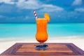 Fresh carrot juice cocktail with straw on wooden table infront of ocean  at the beach Royalty Free Stock Photo