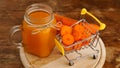 Fresh carrot juice with supermarket cart and on wooden background