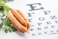 Fresh carrots as a source of vitamin A placed on the eye test chart