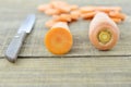 Fresh carrots, cuts with knife on wooden table, closeup Royalty Free Stock Photo