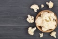 Fresh cauliflower cut into small pieces on black wooden background with copy space for your text. Top view. Flat lay Royalty Free Stock Photo