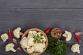 Fresh cauliflower with garlic and chili peppers on black wooden background with copy space for your text. Top view Royalty Free Stock Photo