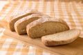 Fresh chabata bread cut into pieces on a wooden board, yellow towel, minimalism Royalty Free Stock Photo