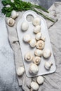 Fresh champignon mushrooms on a white chopping Board. Gray background. Top view Royalty Free Stock Photo