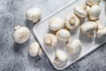 Fresh champignon mushrooms on a white chopping Board. Gray background. Top view Royalty Free Stock Photo