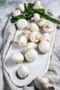 Fresh champignon mushrooms on a white chopping Board. Gray background. Top view Royalty Free Stock Photo