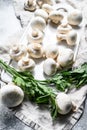 Fresh champignon mushrooms on a white chopping Board. Gray background. Top view Royalty Free Stock Photo