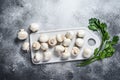 Fresh champignon mushrooms on a white chopping Board. Gray background. Top view. Space for text Royalty Free Stock Photo