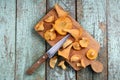 Fresh chanterelle mushrooms cut with wooden handle knife on old