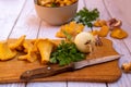 fresh chanterelle mushrooms with fresh vegetables, onions, garlic, parsley, on a board with a cooking knife, top view. Royalty Free Stock Photo