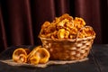 Fresh chanterelle mushrooms gathered in the forest, in a wicker basket and on a wooden background Royalty Free Stock Photo