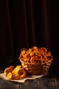 Fresh chanterelle mushrooms gathered in the forest, in a wicker basket and on a wooden background Royalty Free Stock Photo