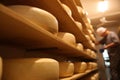 Cheese heads in factory warehouse and blurred worker on background