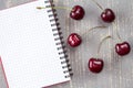 Fresh cherries and blank notebook. Royalty Free Stock Photo