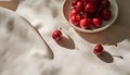 Fresh cherries in a bowl on a white tablecloth, top view