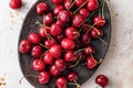 Fresh cherries close up in brown oval plate on white textured background, top view Royalty Free Stock Photo