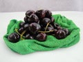 Fresh cherries fruits wrapped in cloth on green background Royalty Free Stock Photo