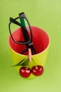 Cherries and glasses on green background Royalty Free Stock Photo
