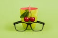 Cherries and glasses on green background Royalty Free Stock Photo