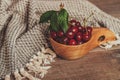 Fresh cherries with green leaves in wooden bowl Royalty Free Stock Photo