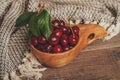 Fresh cherries with green leaves in wooden rustic bowl Royalty Free Stock Photo