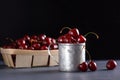 Fresh cherries in a metal mug on a black background. Dark moody photo Royalty Free Stock Photo