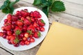 Fresh cherries and red ripe strawberries on a white plate Royalty Free Stock Photo