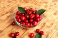 Fresh cherries in transparent plate on wooden table. Red berry cherry, harvesting Royalty Free Stock Photo