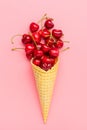 Fresh cherries in waffle cones Ice cream cone filled with fresh sweet cherry on pink background. Top view. Copy space. Summer Royalty Free Stock Photo