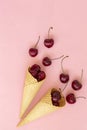 Fresh cherries in waffle cones. Ice cream cone filled with fresh cherries on a pink background. Top view. Copy space. Royalty Free Stock Photo