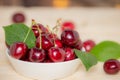 Fresh cherries in the white bowl on wood table