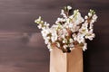 Fresh Cherry Blossoms in Paper Bag on Wooden Table