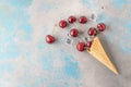 Fresh cherry fruits and ice cubes coming out from ice cream cone